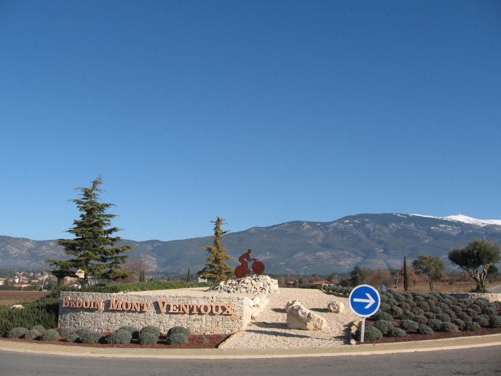 a sign in front of a park with mountains in the background at La maisonnette in Crillon-le-Brave