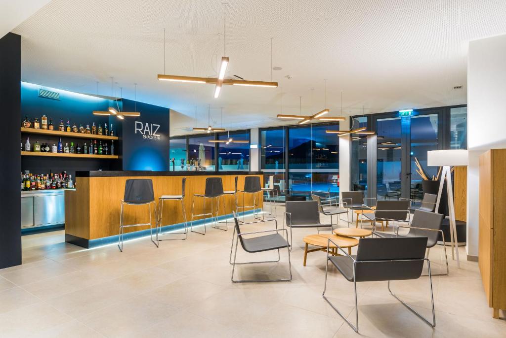 a restaurant with chairs and tables and a bar at Vila Baleira Village in Porto Santo