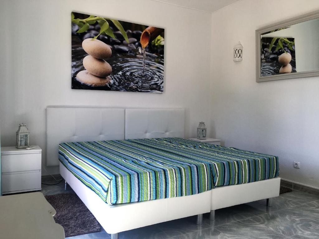um quarto com uma cama e uma fotografia na parede em Farol Aldeia das Chaminés em Carvoeiro