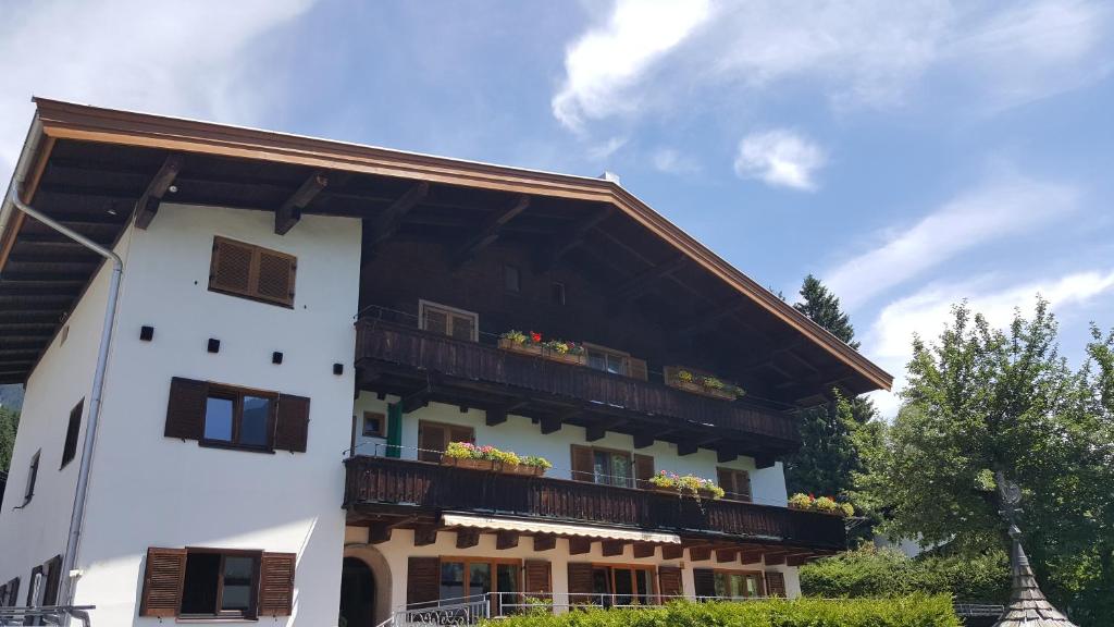 a white building with a balcony with flowers on it at Gästehaus Wallner in Kitzbühel