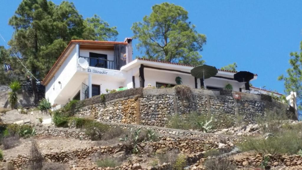 uma casa no topo de uma parede de pedra em El Mirador em Vilaflor
