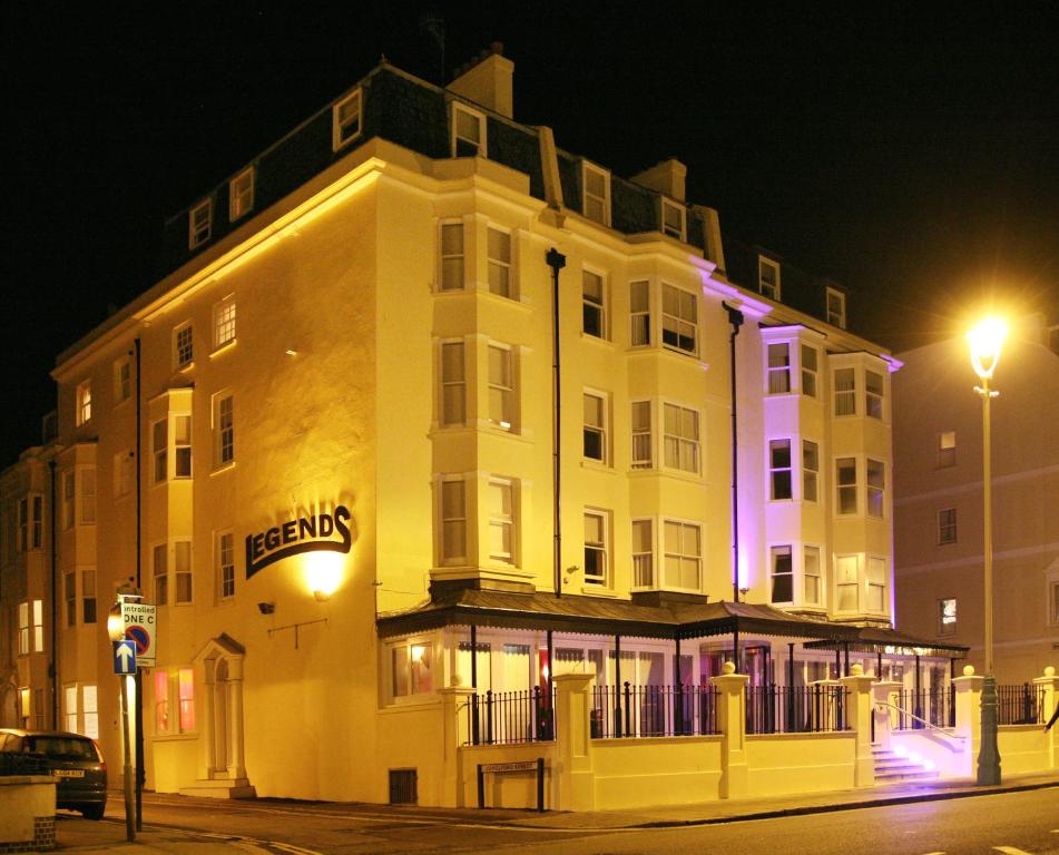 a large white building with a sign on it at night at Legends Hotel in Brighton & Hove
