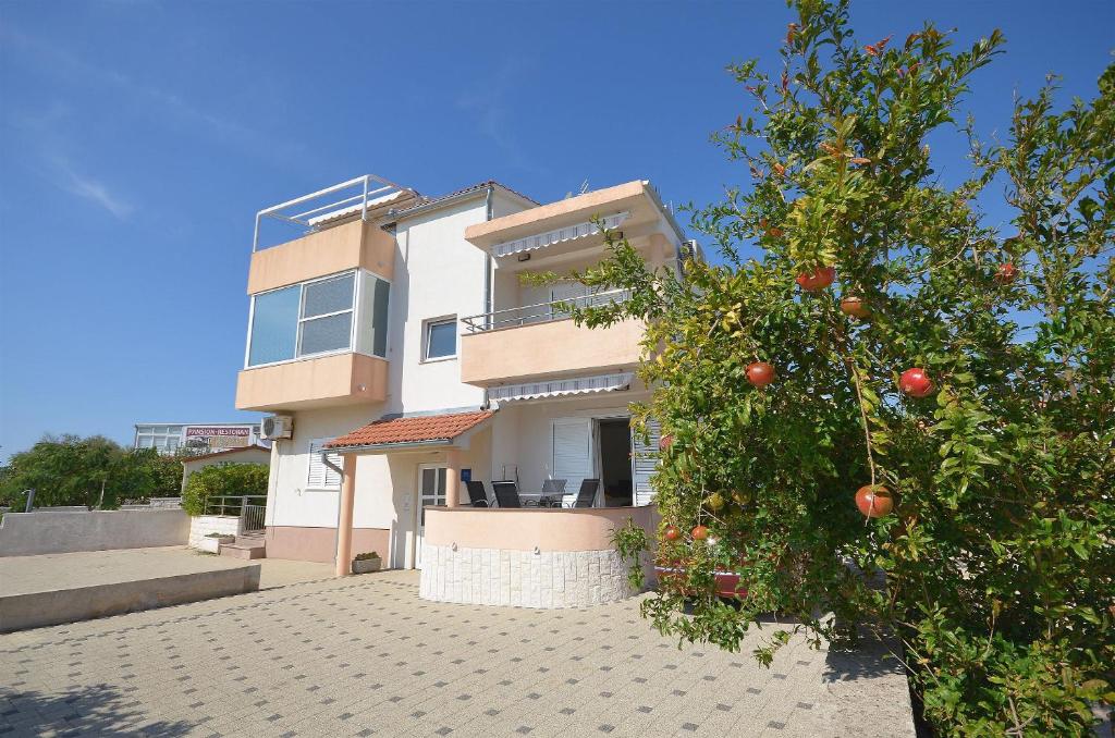 a house with an orange tree in front of it at Apartment Srima in Srima