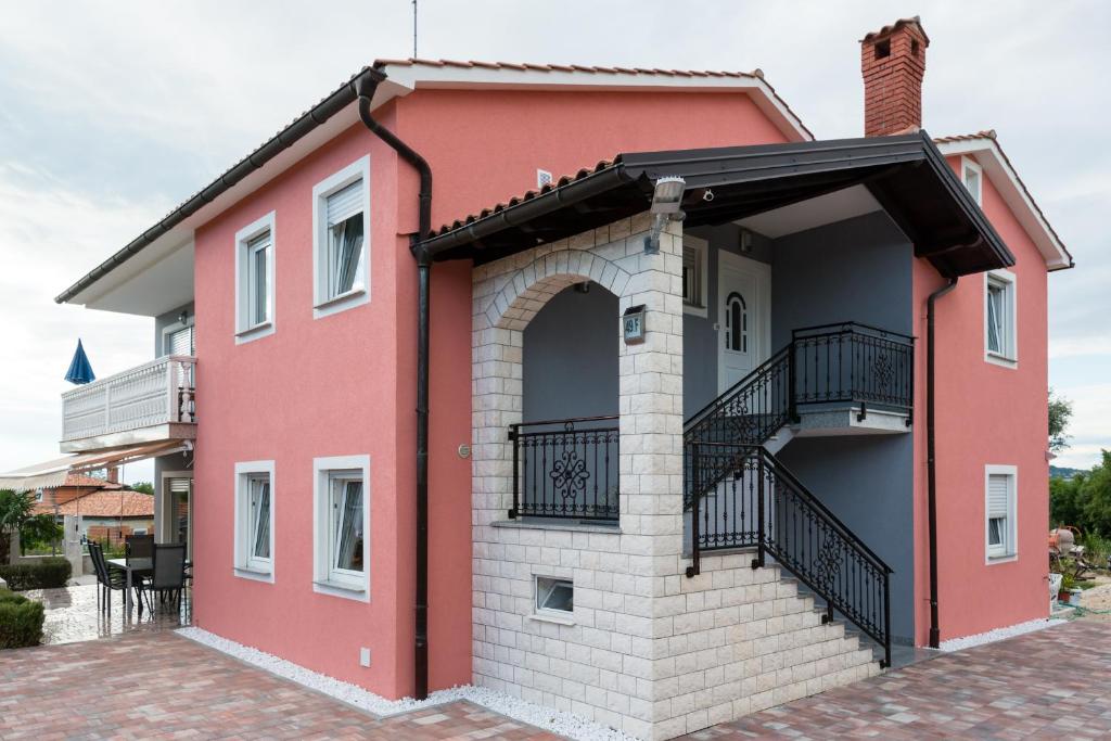 a red and white house with a balcony at Ferienhaus Bucic in Buje