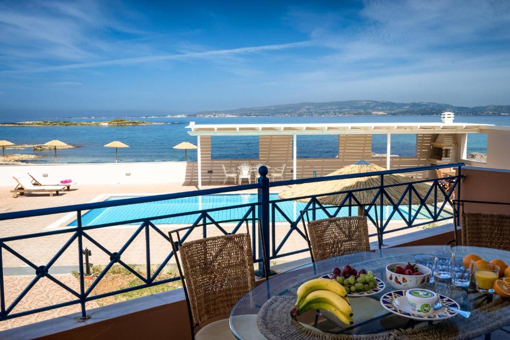 a table with fruit on a balcony with a view of the ocean at Villas Cape in Minia