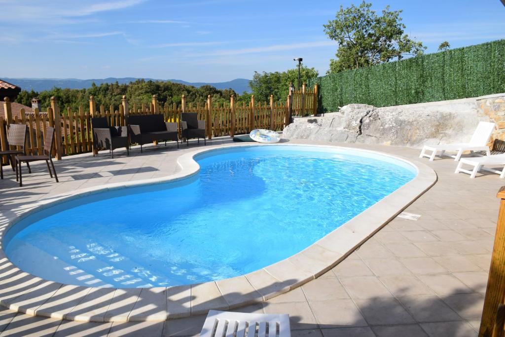 a swimming pool in a backyard with chairs and a fence at Agriturismo Aria Fina in Mormanno