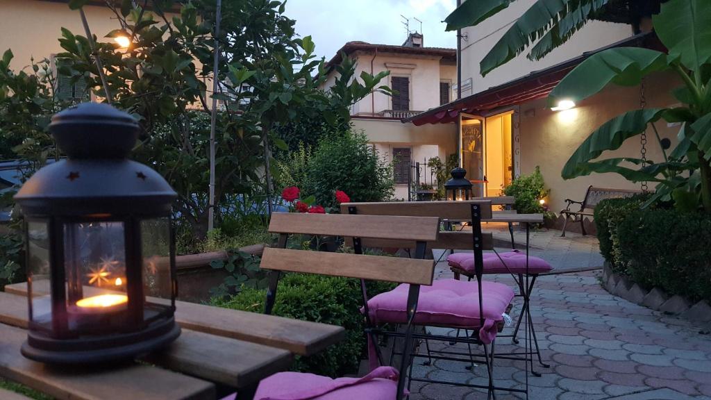 un patio con una mesa y sillas con una linterna en Hotel Soggiorno Athena, en Pisa