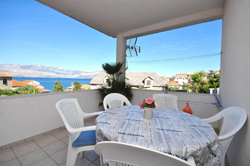 a table on a balcony with a view of the ocean at Apartment Katija in Postira
