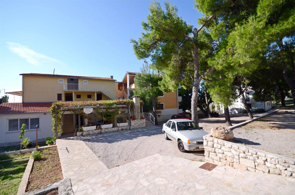 a white car parked in front of a house at Apartments Marija in Ivan Dolac