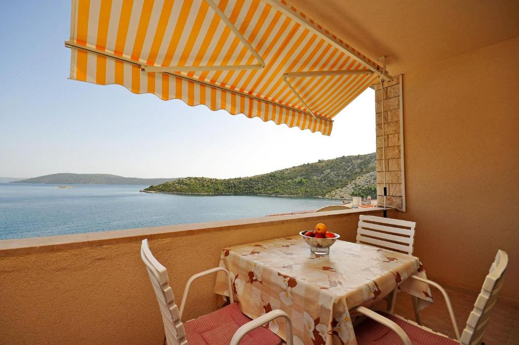 a dining room with a table and a view of the ocean at Apartments Val in Vinišće