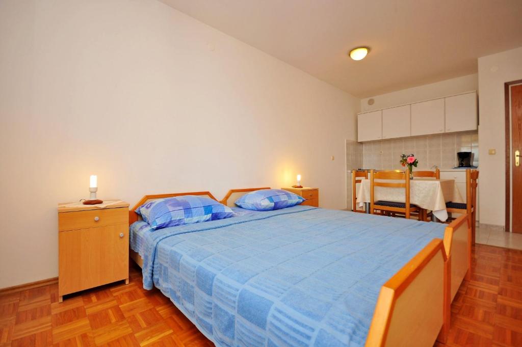a bedroom with a large blue bed with blue pillows at Apartments Val in Vinišće