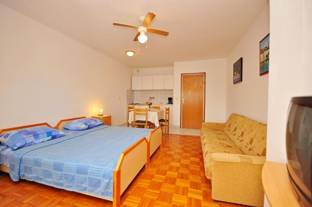 a bedroom with a bed and a couch at Apartments Val in Vinišće