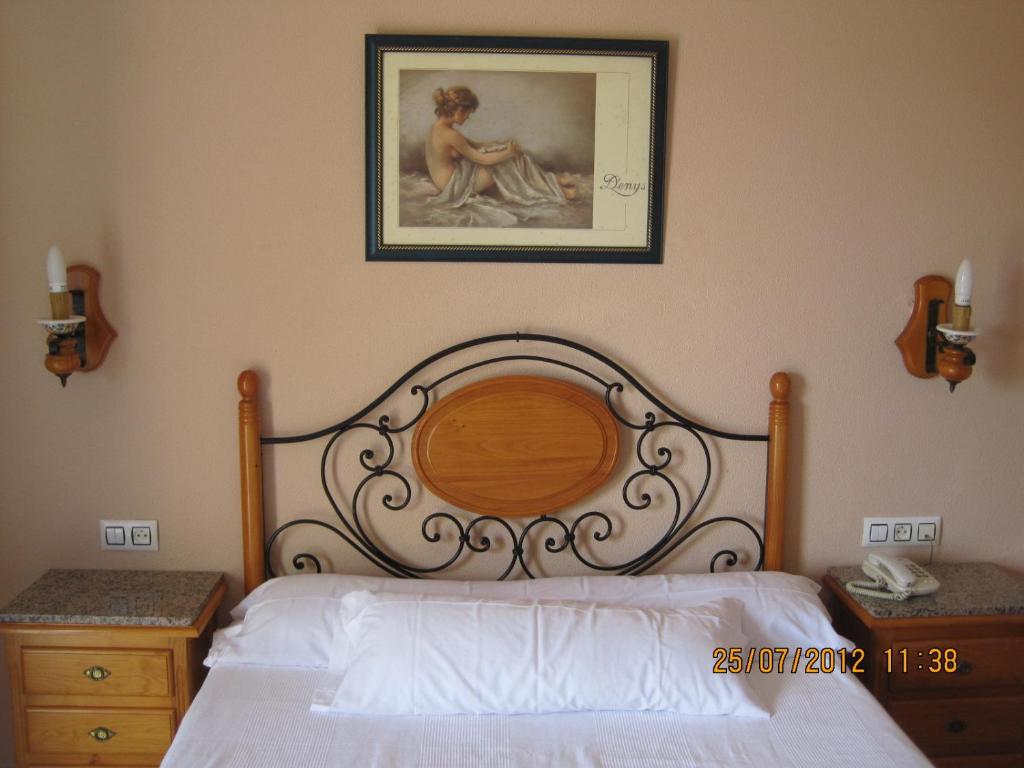 ein Schlafzimmer mit einem Bett und einem Bild an der Wand in der Unterkunft Hotel Caballo Negro in Puerto Real