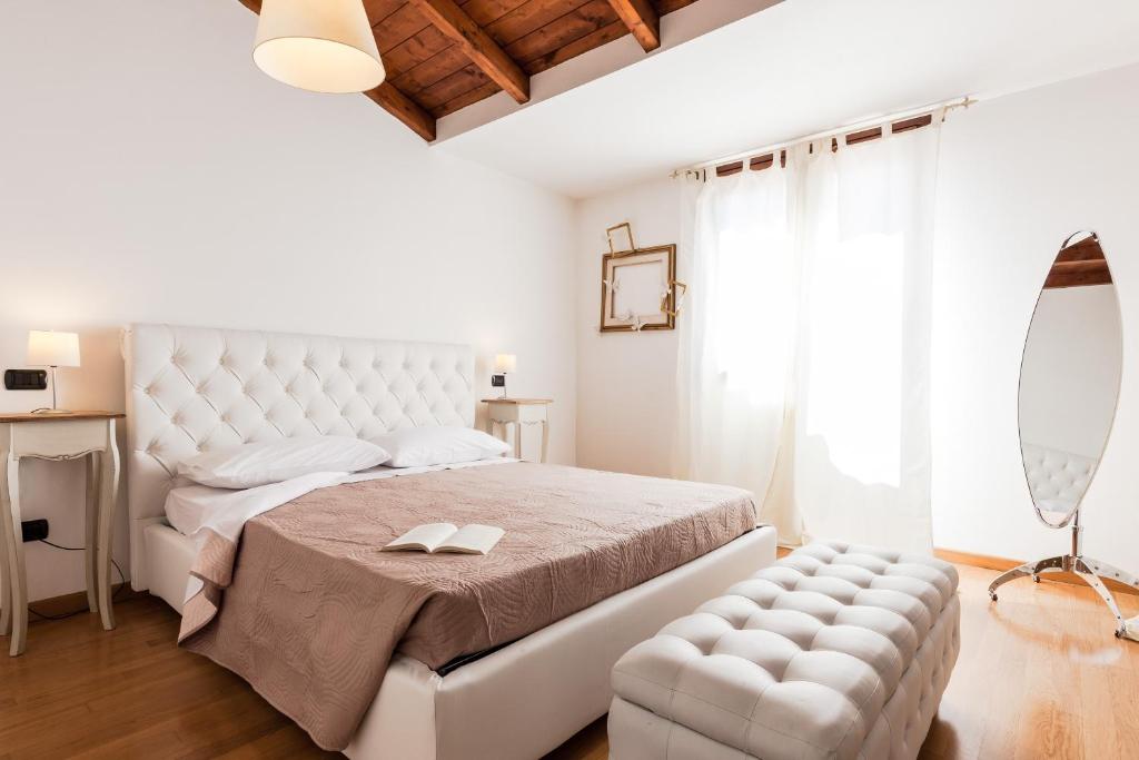 una camera bianca con un grande letto e una sedia di Villa Hermosa a Quartu SantʼElena