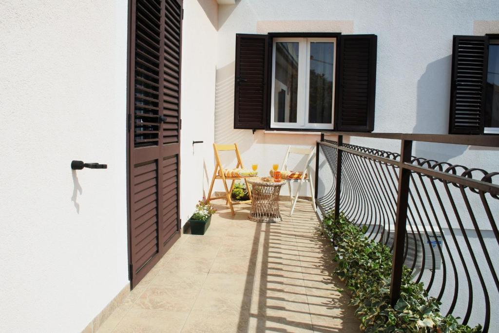 a small balcony with a table and a window at Apartment Anton in Slatine
