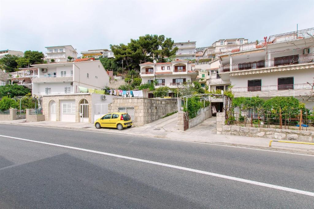 a yellow car parked on the side of a street at Apartments Nevenka in Sumpetar