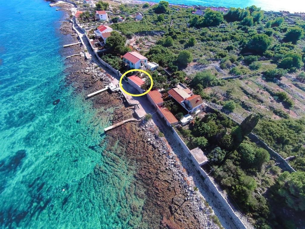 eine Luftansicht auf einen Strand mit gelbem Kreis in der Unterkunft House Mislav in Velike Kuknjare