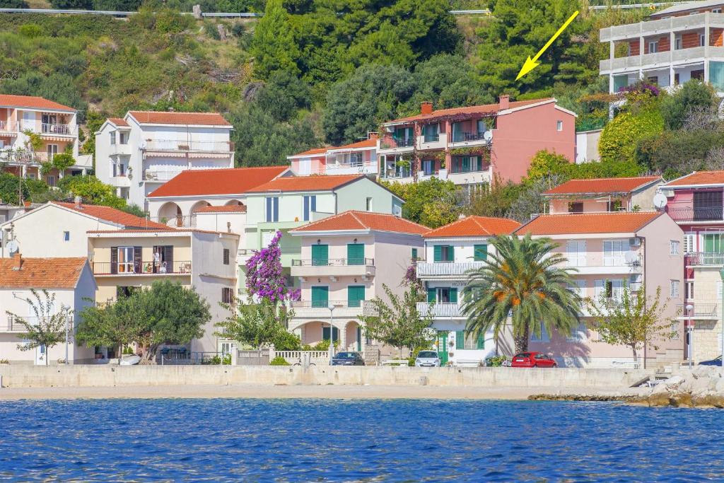 a group of houses on a hill next to the water at Apartments Kunac in Podgora