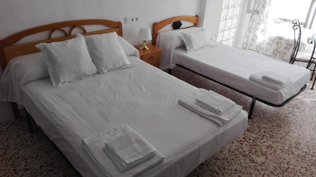 2 camas en una habitación de hotel con sábanas blancas en Pension Centro en Guardamar del Segura