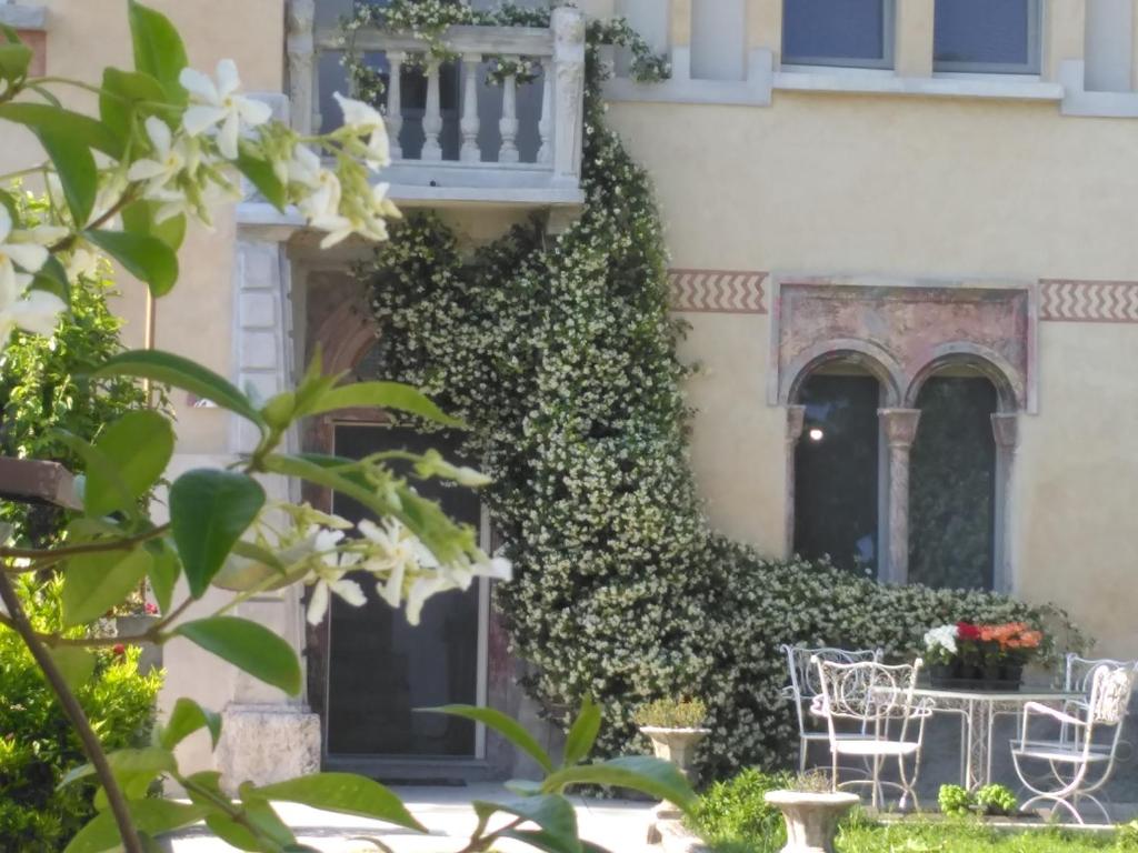 a building covered in ivy with chairs and a table at B&B Casa Lulù in Brembate