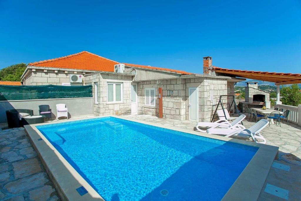 - une piscine avec des chaises et une maison dans l'établissement House Ivica, à Korčula