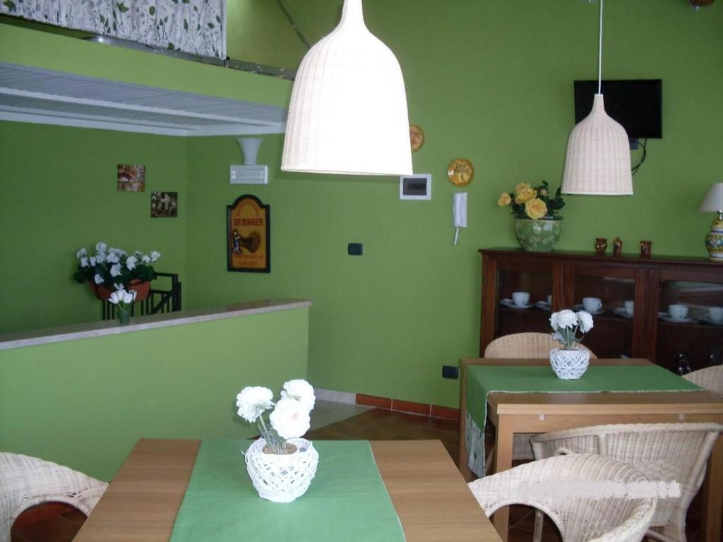 a dining room with green walls and a table and chairs at Le Tre Caravelle in Trabia