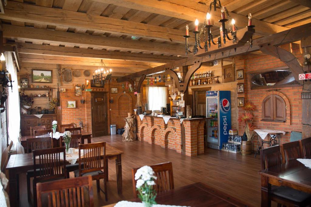 a restaurant with wooden floors and tables and chairs at OBERŻA in Borsuki