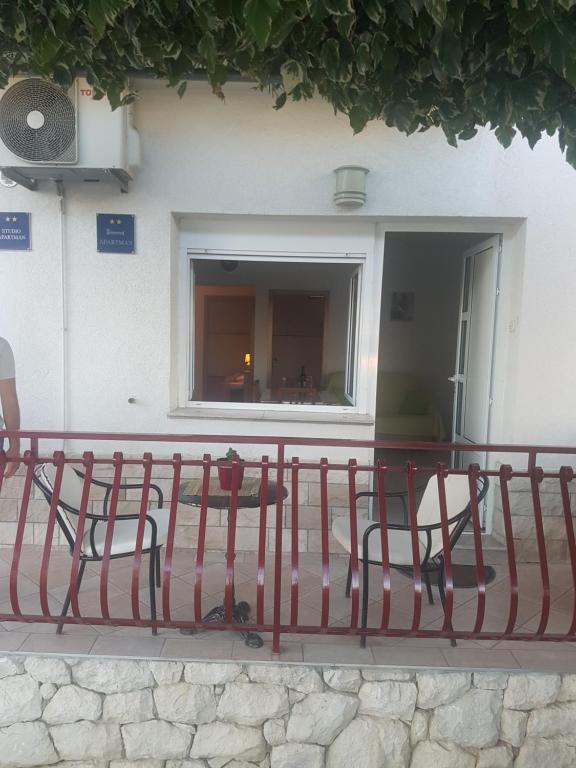 une clôture rouge assise devant un bâtiment dans l'établissement Apartments Dubravka, à Split