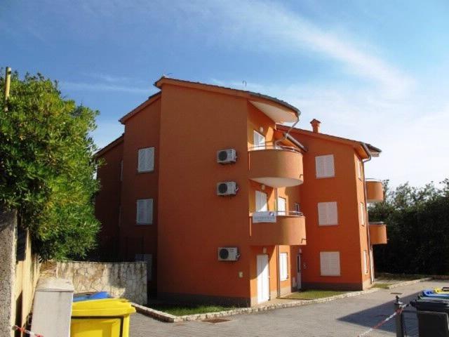 a large orange building with balconies on the side of it at Apartment Ivan in Šilo