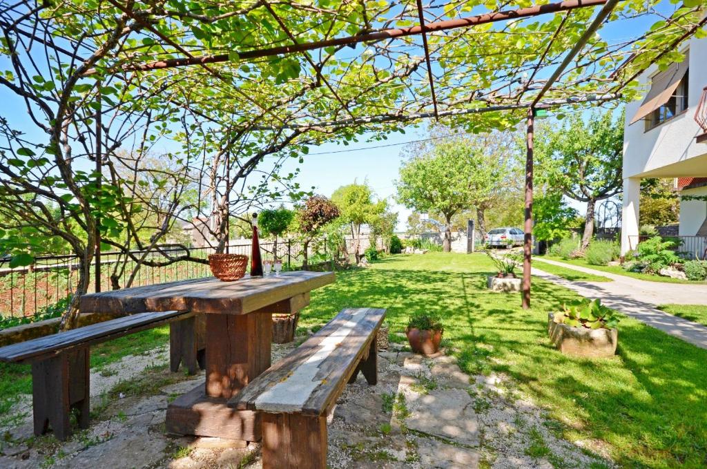 una mesa de picnic y un banco en un patio en Apartment Srblin en Sveti Petar u Šumi