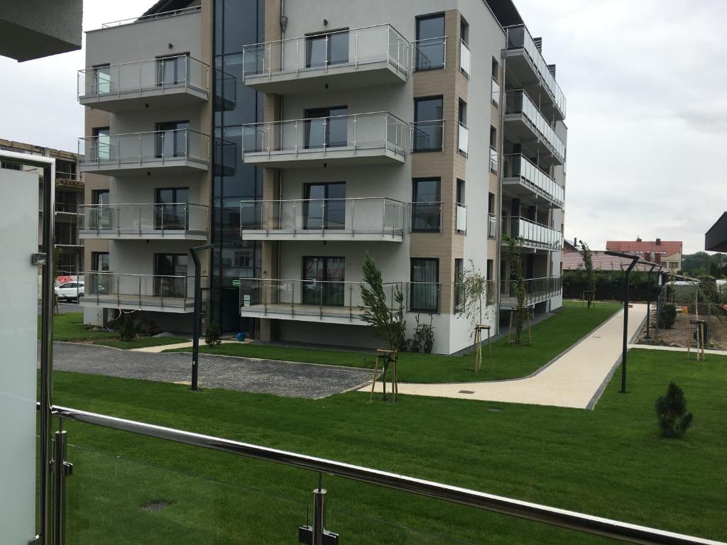an apartment building with a green lawn in front of it at Apartamenty 5 mórz in Sianozety