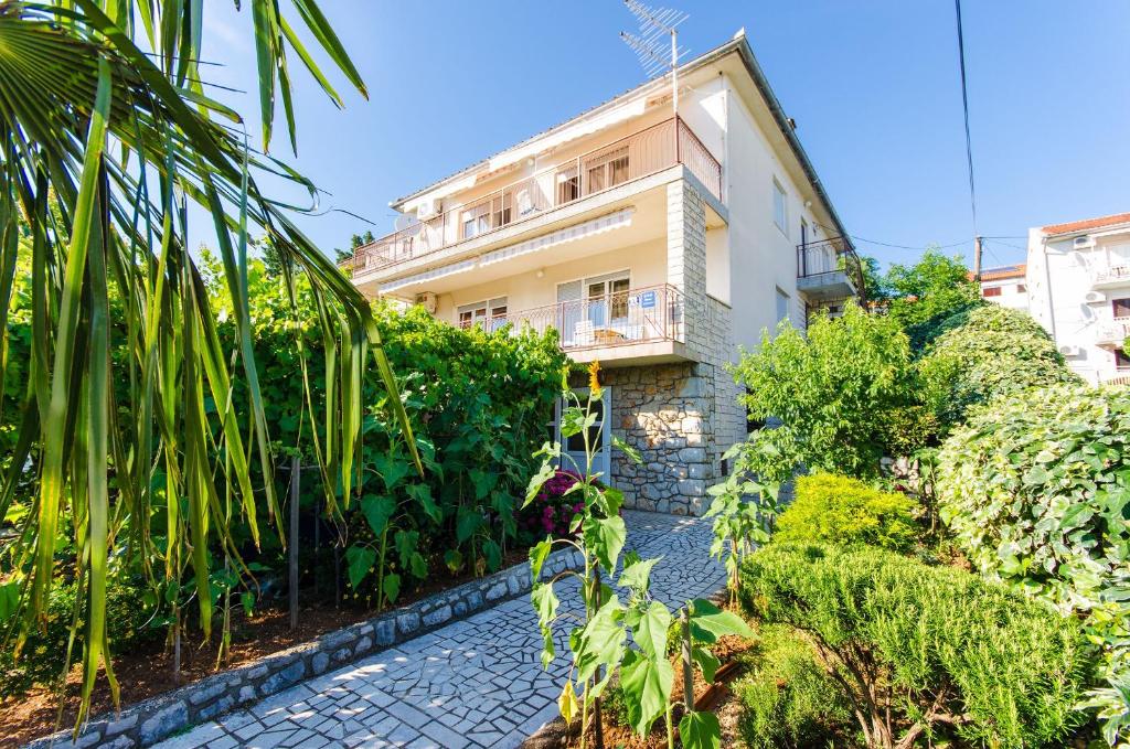 a house with a garden and a stone walkway at Apartments Daria in Selce