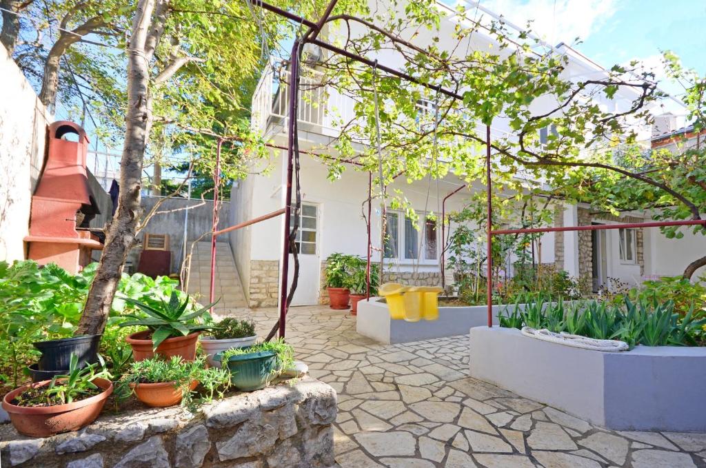 a courtyard with potted plants and a building at Apartments Jasminka in Selce