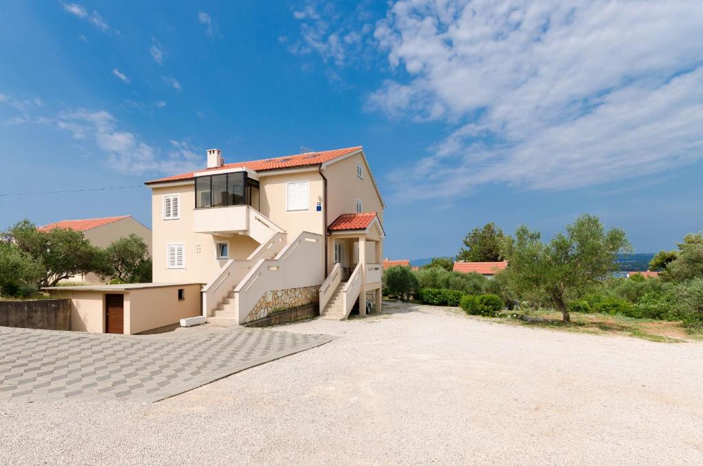 a large white house with a driveway at Apartment Mauro in Punat
