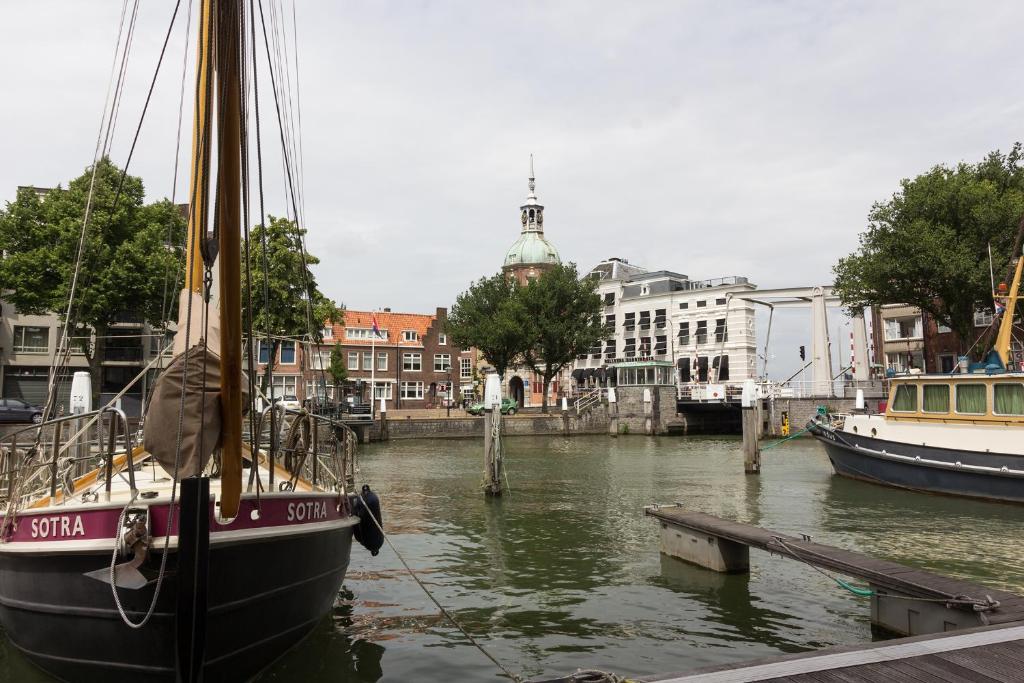 een boot is aangemeerd op een dok in het water bij Divino in Dordrecht