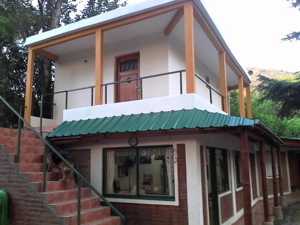 Una pequeña casa con un toldo verde. en Posada A Lo De Santys en Villa Independencia