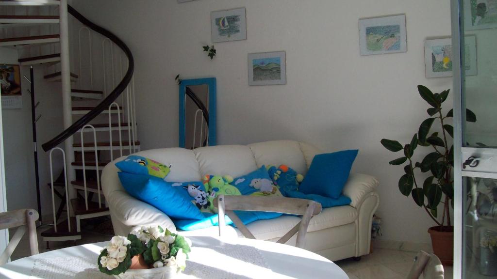 マリーナ・ディ・マッサにあるSunny seaside apartamentのリビングルーム(白いソファ、青い枕付)