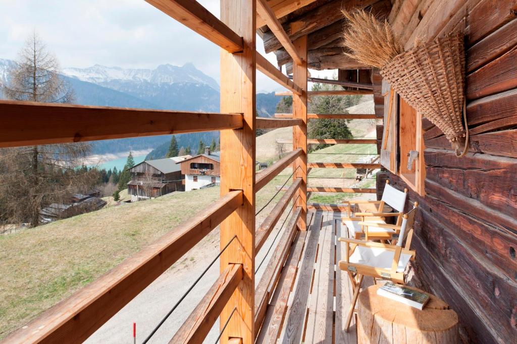 a balcony of a log cabin with a view of the mountains at Albergo Diffuso Sauris in Lateis in Lateis