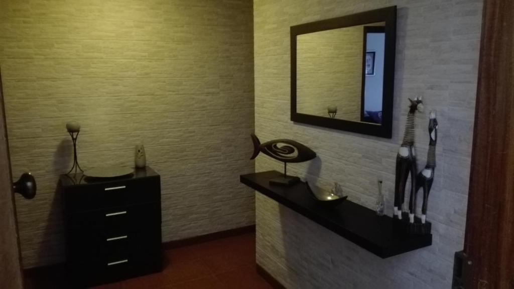 y baño con lavabo y espejo. en Alojamento S. Pedro, en Peniche