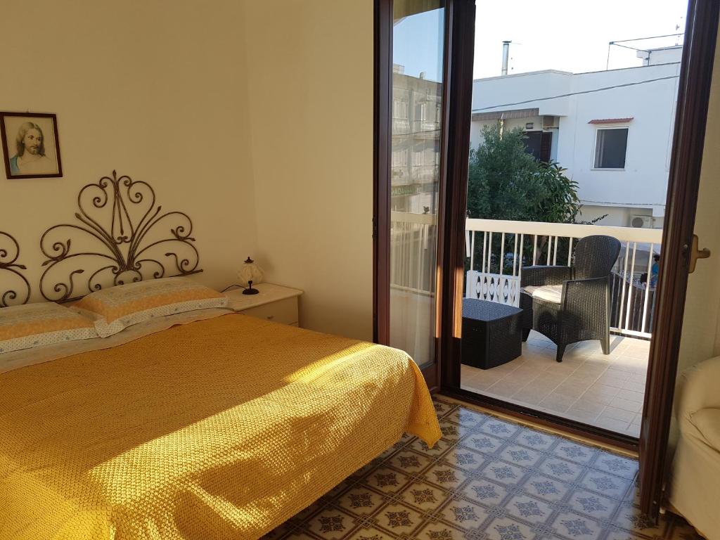 ヴィッラノーヴァ・ディ・オストゥーニにあるAppartamento La Rosa Dei Ventiのベッドルーム(ベッド1台付)、バルコニーが備わります。