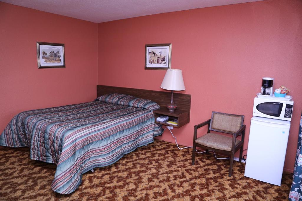 um quarto de hotel com uma cama e uma cadeira em Timberlodge RV & Campground em Port Alberni