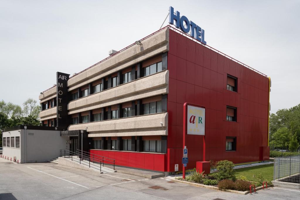 un edificio rosso con un cartello sopra di Hotel Airmotel a Mestre