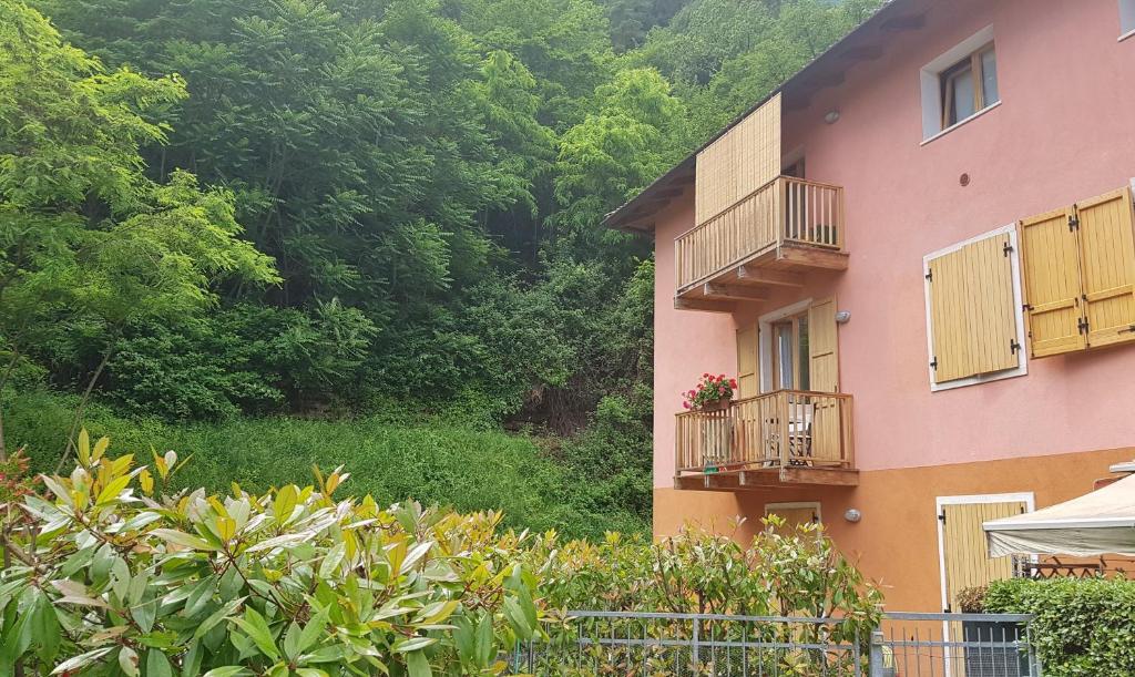 un edificio rosa con balcone fiorito di Appartamento Angi - lago & vacanza attiva a Riva del Garda
