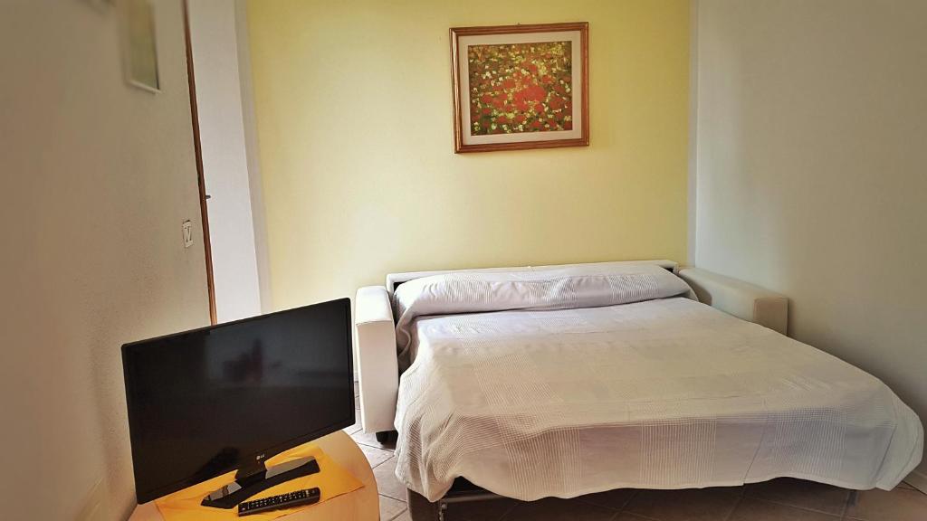 Pokój szpitalny z łóżkiem i telewizorem z płaskim ekranem w obiekcie Appartamento Angi - lago & vacanza attiva w mieście Riva del Garda