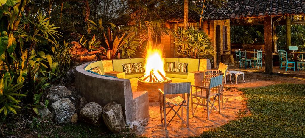 a fire pit with a couch and chairs and a table at Pousada Famiglia Bartho in Espirito Santo Do Pinhal