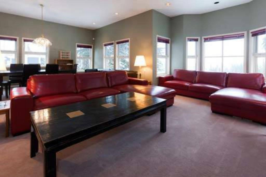 a living room with a red couch and a table at Vacation Homes by The Bulldog- Henk's Haven in Silver Star