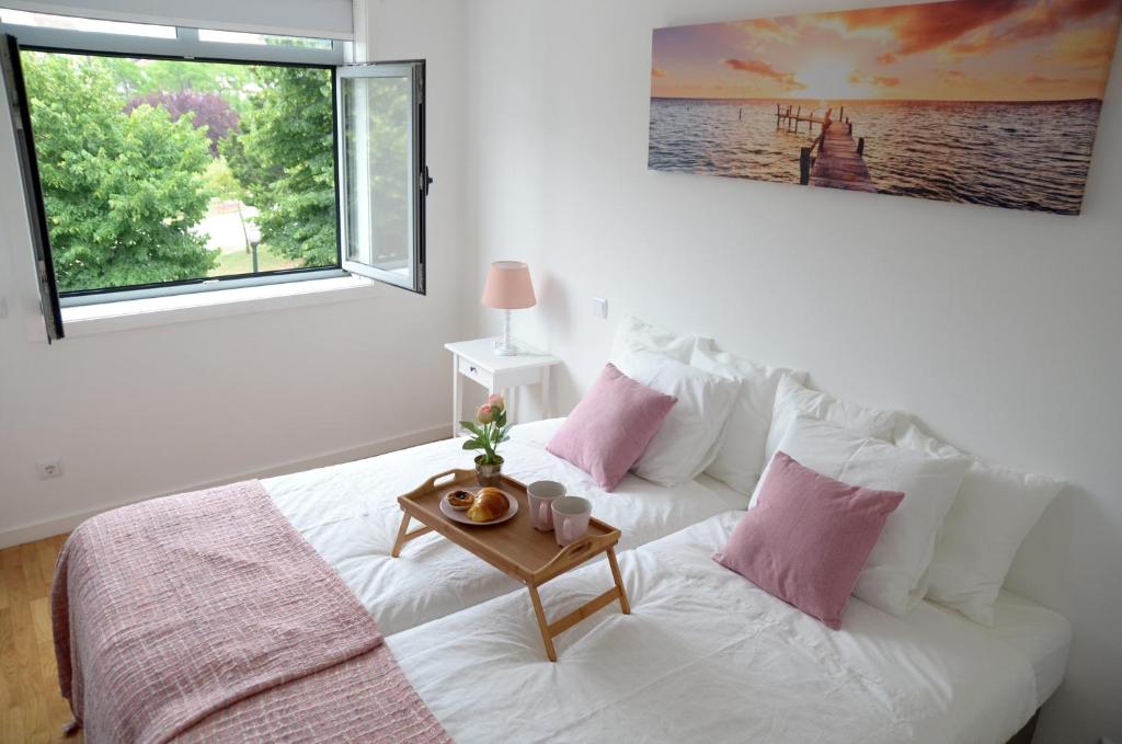 ein Schlafzimmer mit einem weißen Bett und einem Tisch darauf in der Unterkunft Porto Smart Apartments - Downtown in Porto