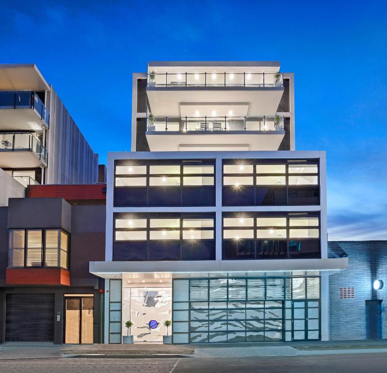 um edifício alto com muitas janelas em The Hamptons Apartments - Port Melbourne em Melbourne