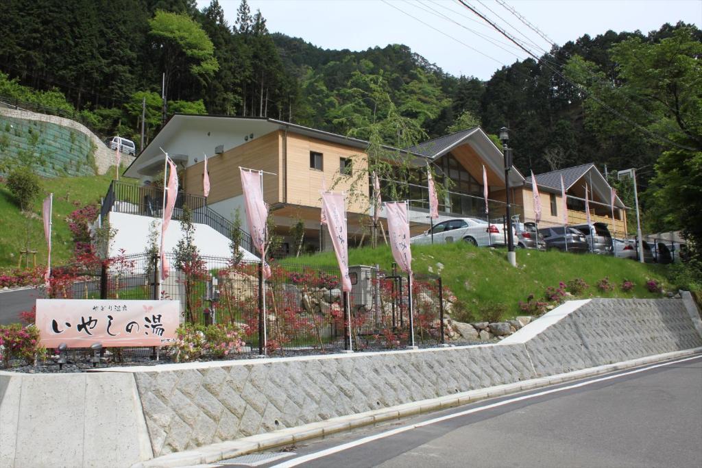 une clôture avec un panneau sur le côté d'une route dans l'établissement Yadori Onsen Iyashinoyu, à Hashimoto