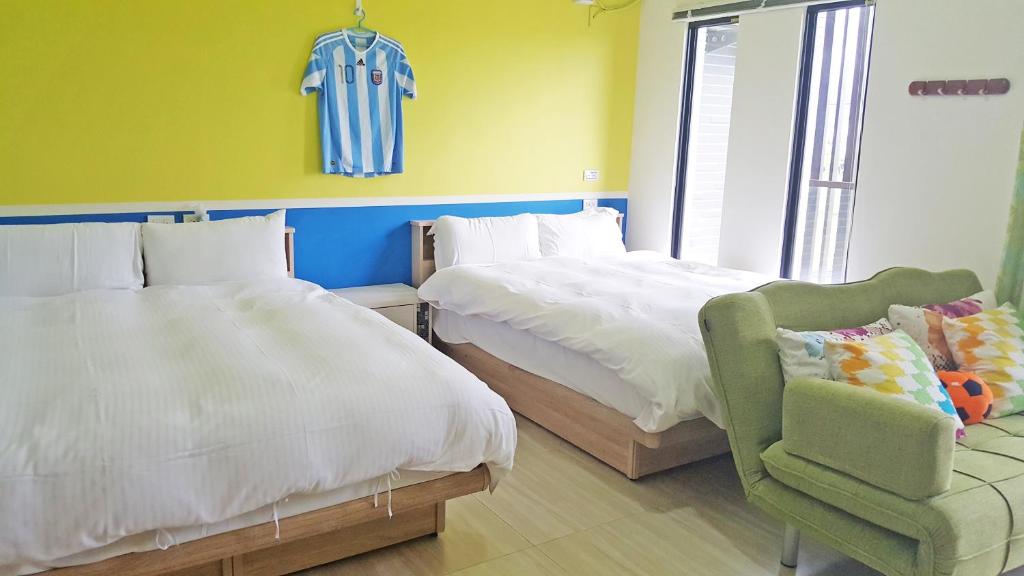 1 dormitorio con 2 camas, 1 silla y 1 camiseta en la pared en Sports Home, en Xingjian